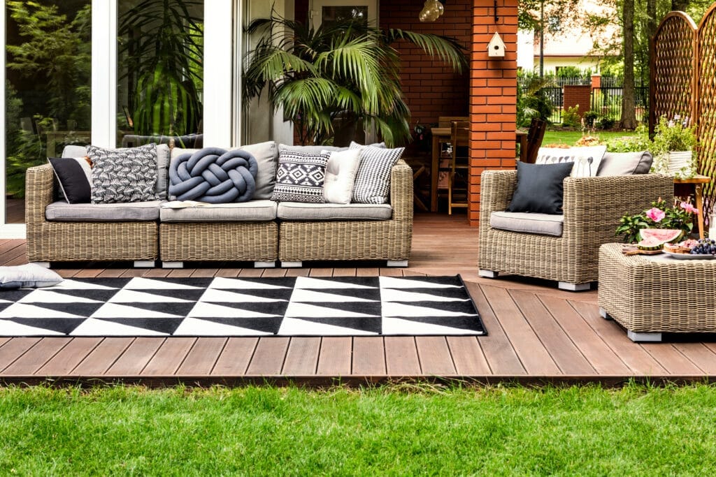 patio design with wicker furniture, stained decking and a black and white carpet