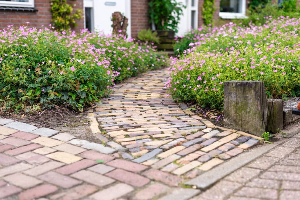 Intersecting brick pathways surrounded by flowers as an example of summer hardscaping