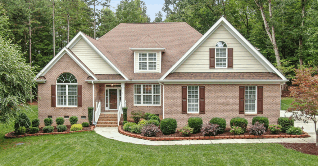 A well-maintained suburban house with impeccable landscaping and a freshly mown lawn, following the lawn requirements for the Louisville metro area beautifully.