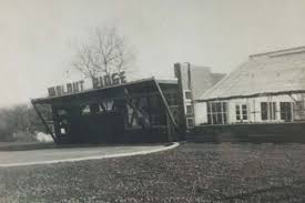 Black and white photo of a building with a sign reading Walnut Ridge. The very first building of the family-owned landscaping company.